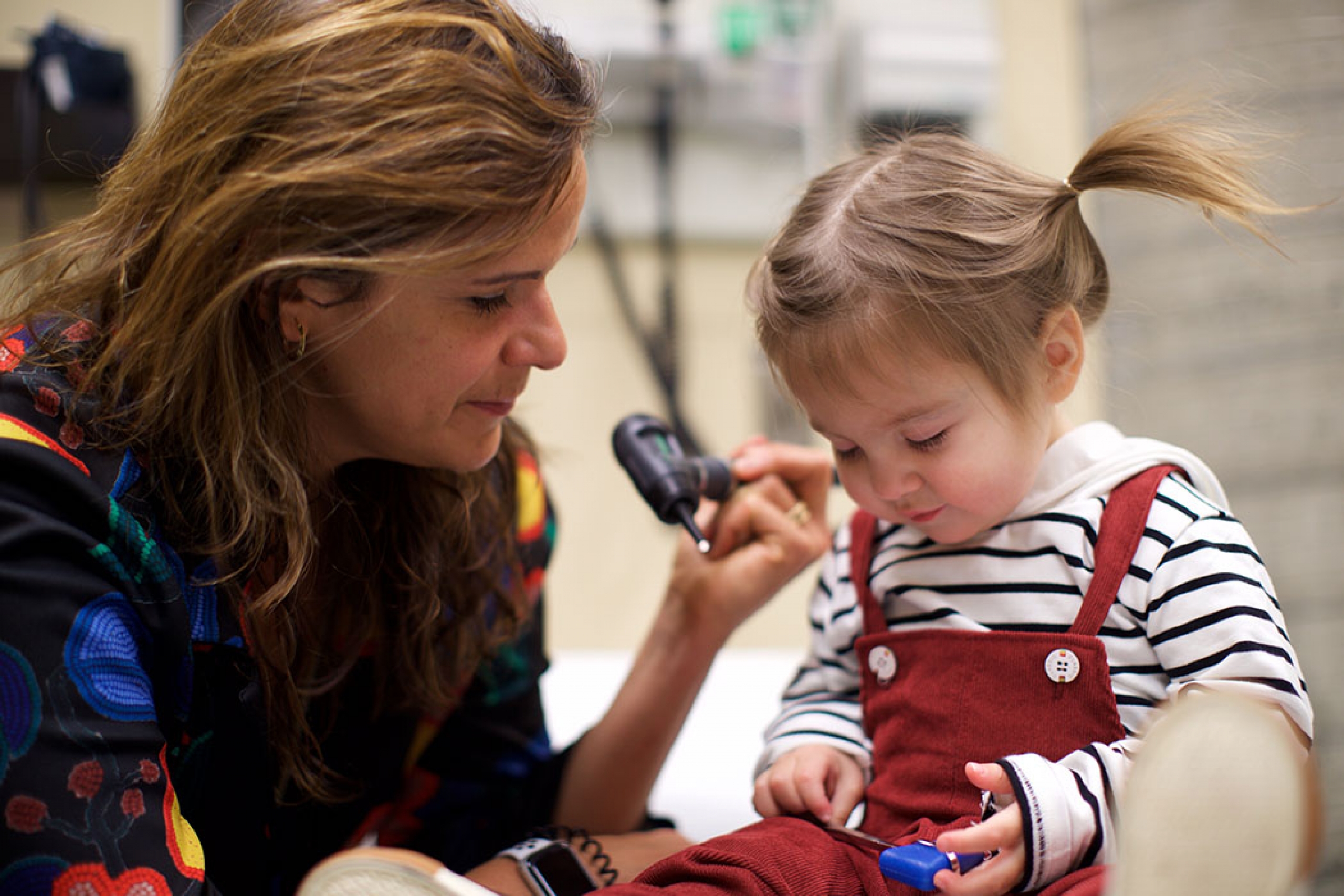 Physician examines toddler.