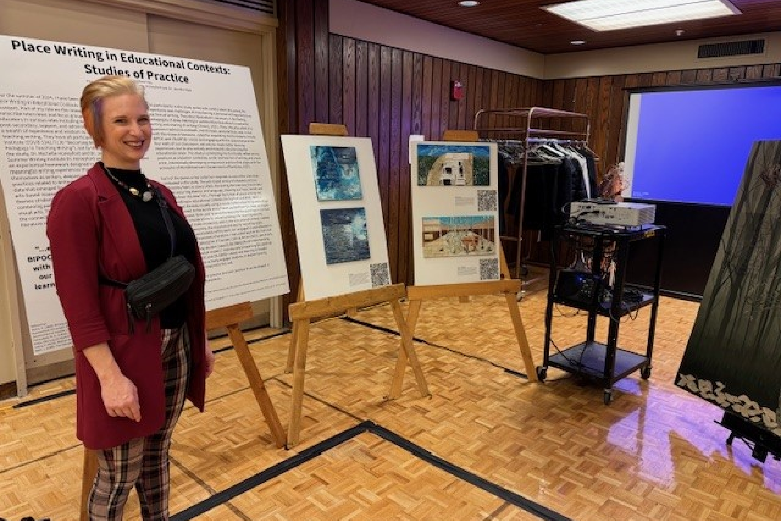 student stands with research poster