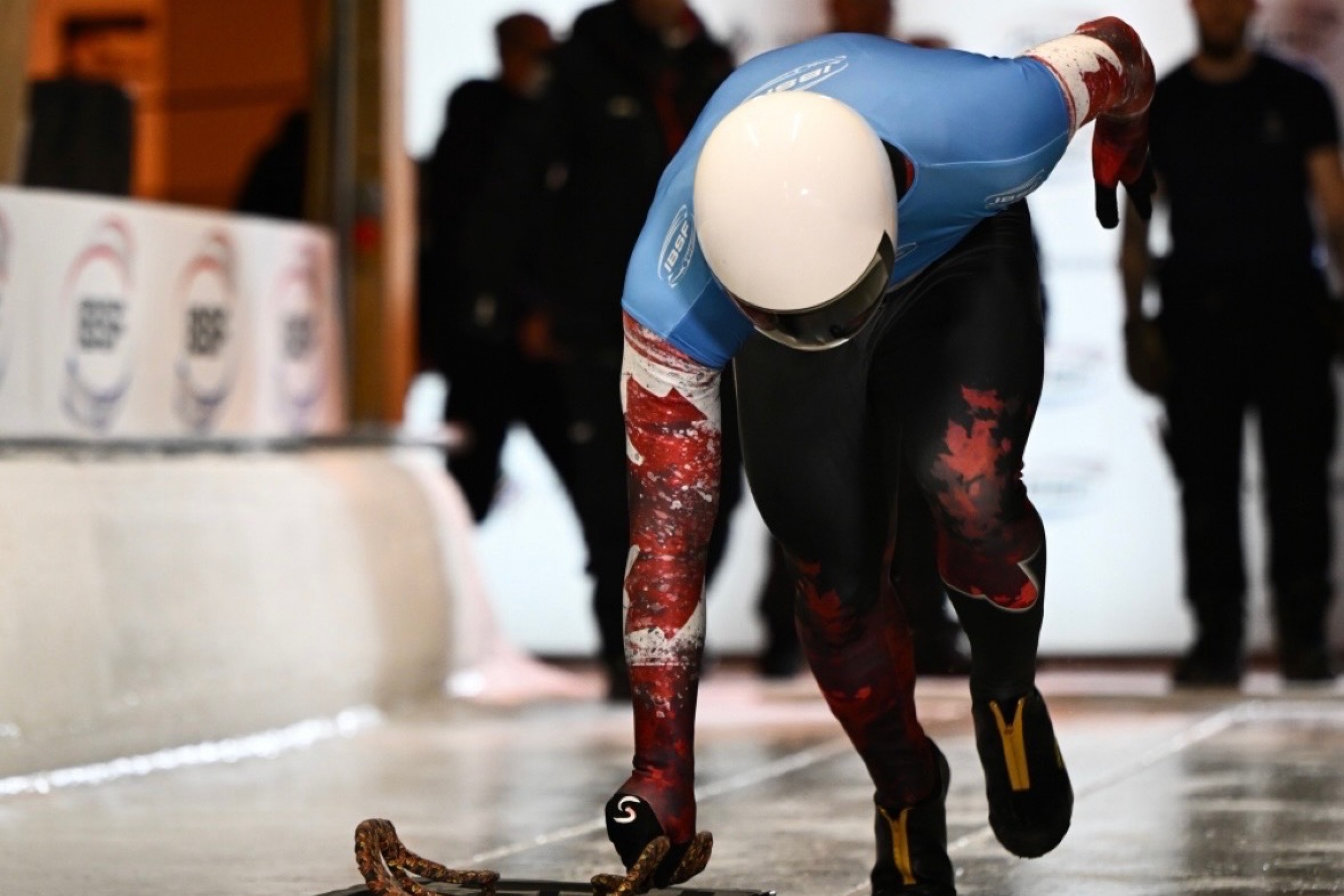 An athlete in the start chute for a skeleton race sprints toward the camera