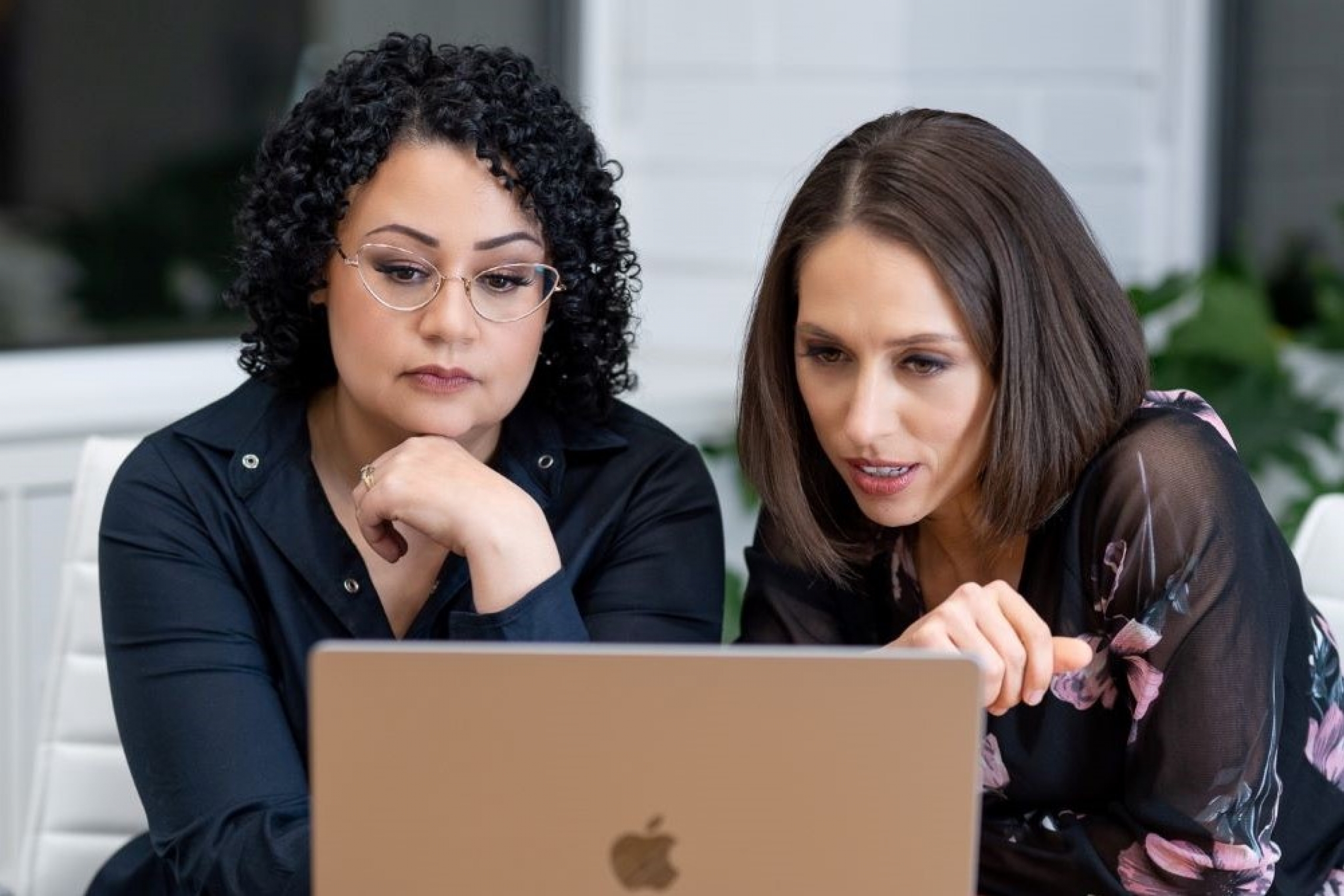 Natalie Rodriguez and Dr. Meghan Azad sit side-by-side looking at a laptop screen.