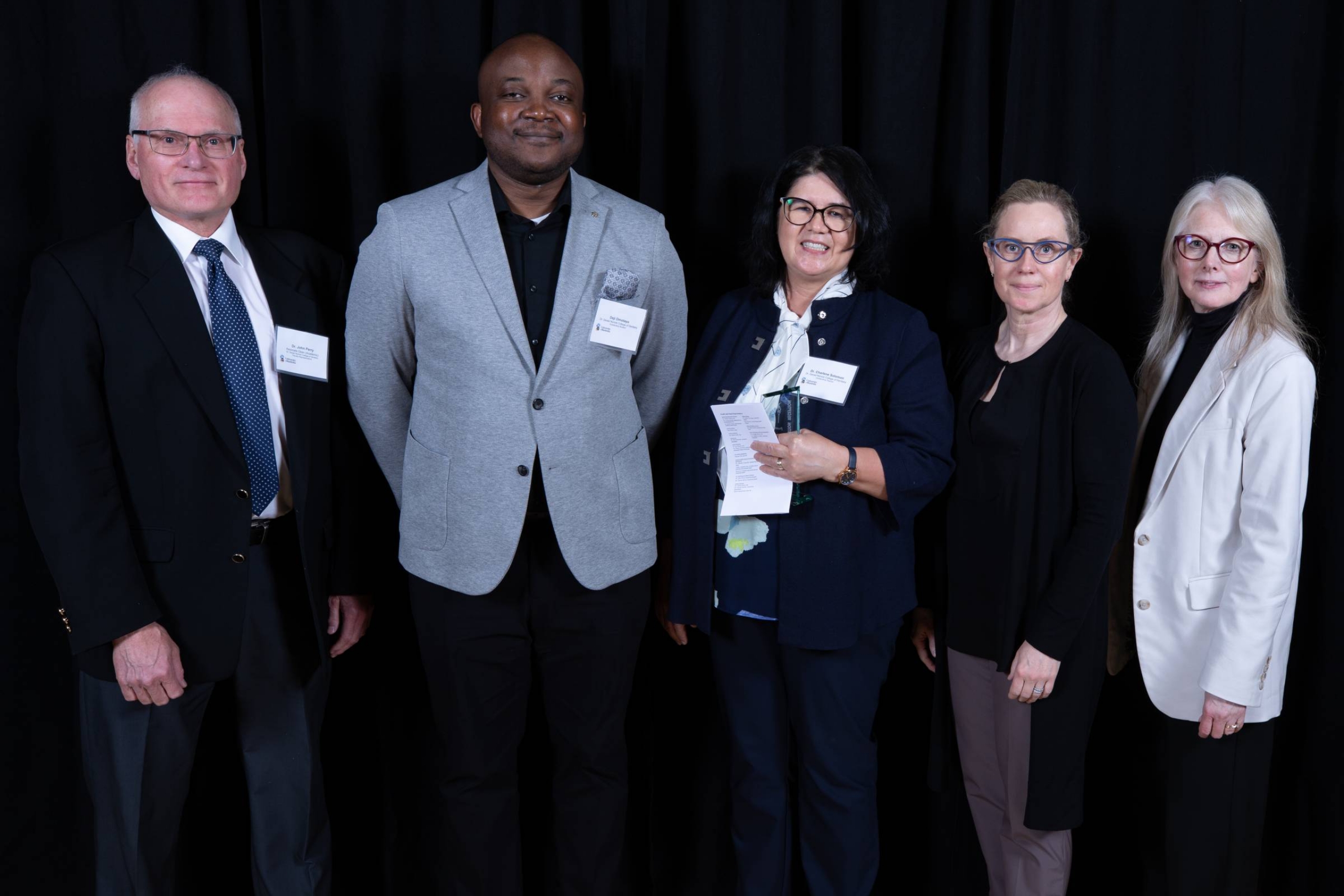 Recipients of STRR awards stand in front of a backdrop for a posed picture.