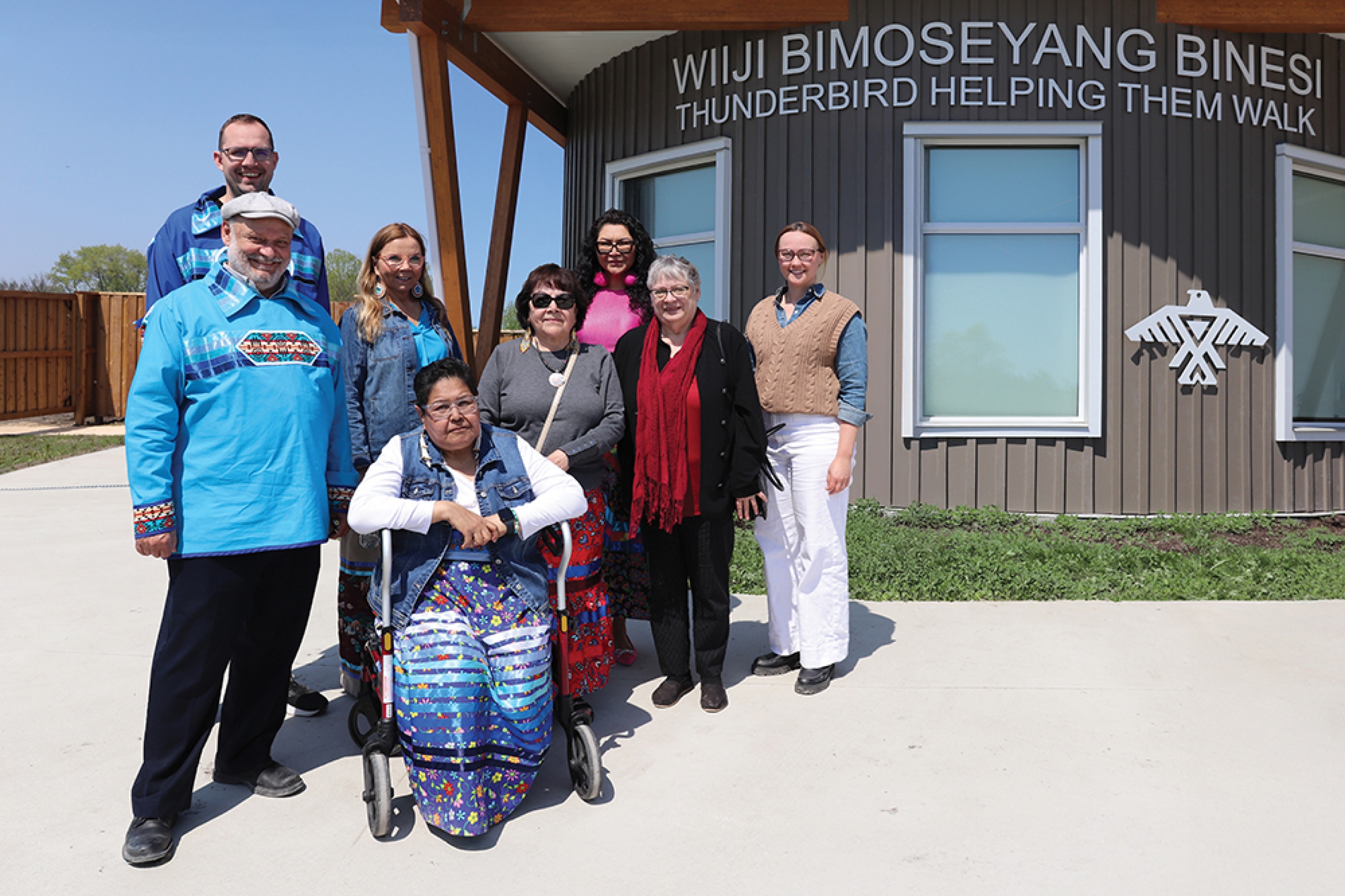 Eight people pose for a group photo outside Wiiji Bimoseyang Binesi.