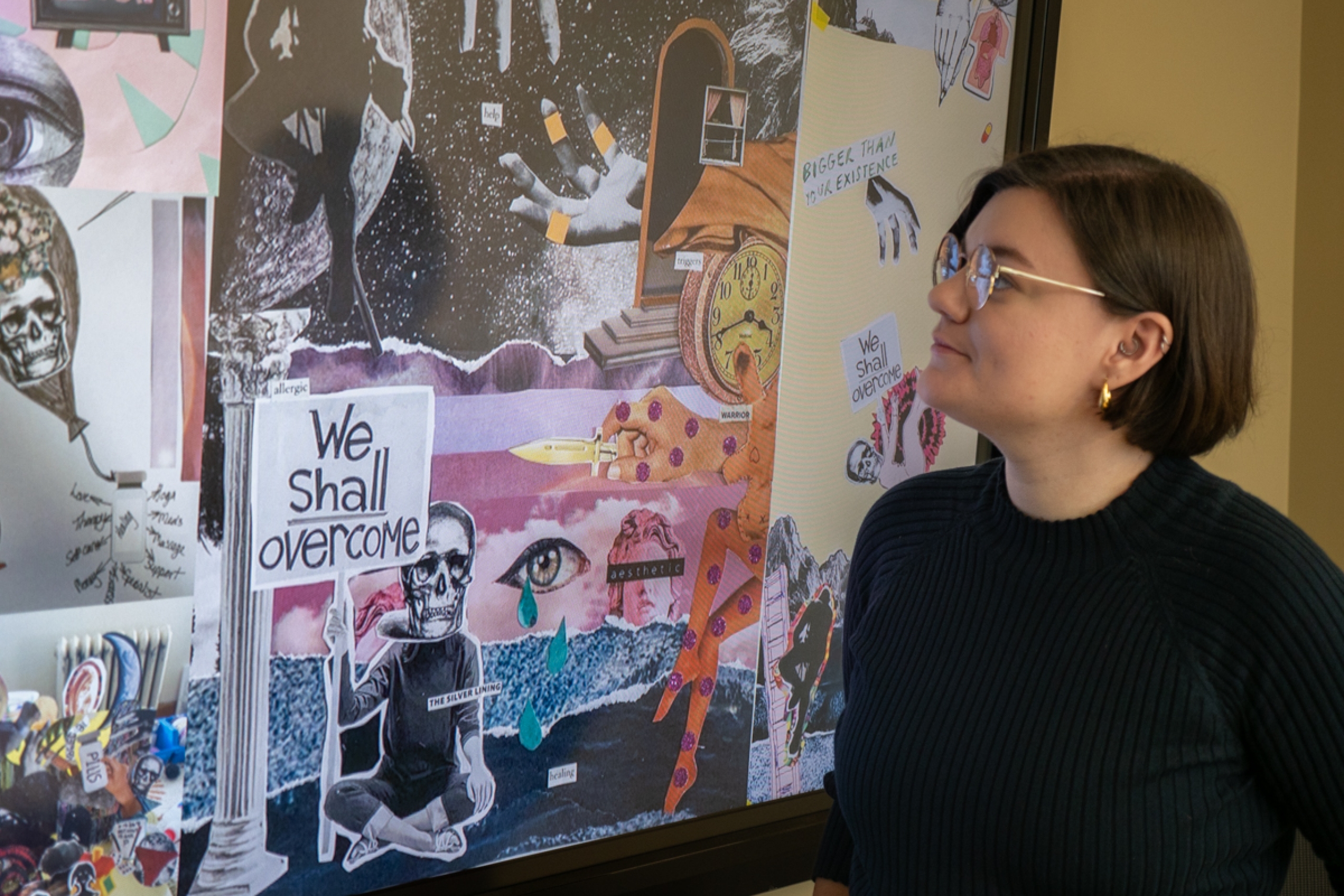 Jen Sebring looks at a digital display showing a collage of participant-created artwork.