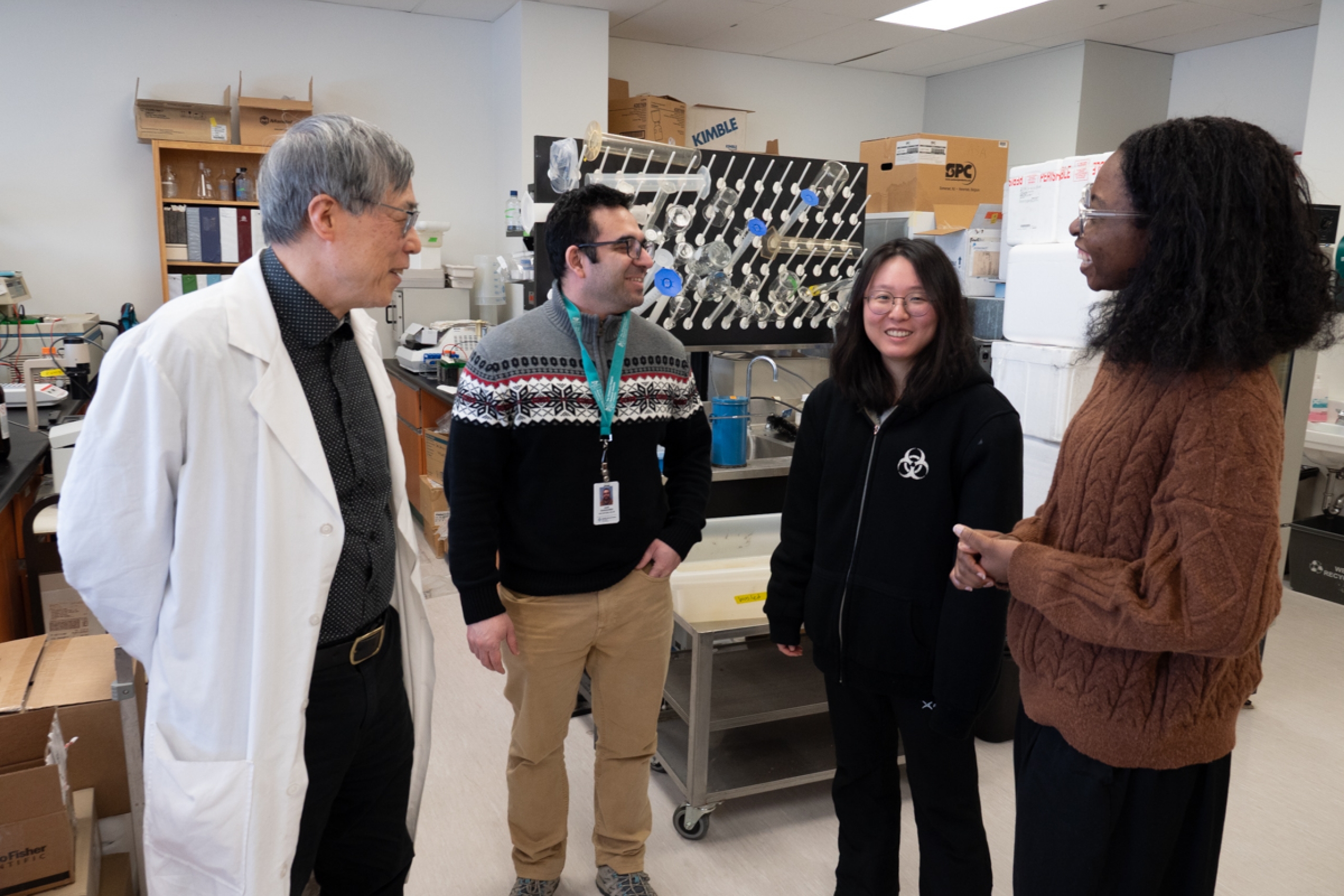 Four individuals talking to each other in a laboratory.