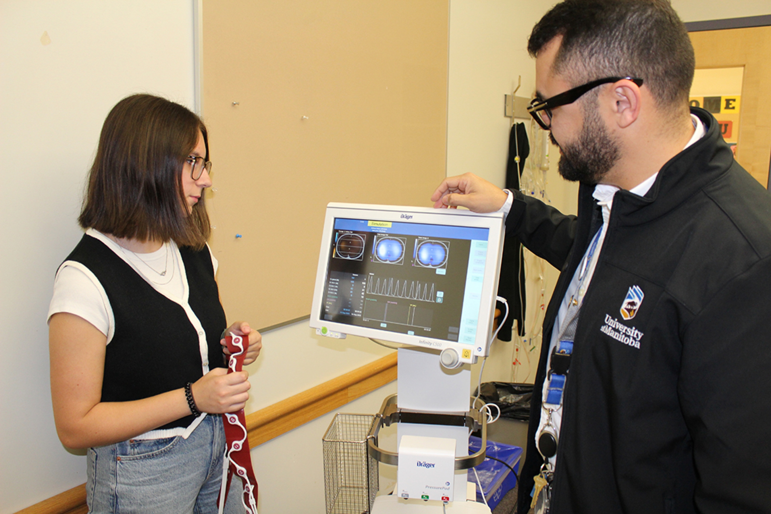 A student and professor look at a computer screen showing electrical impedance tomography.