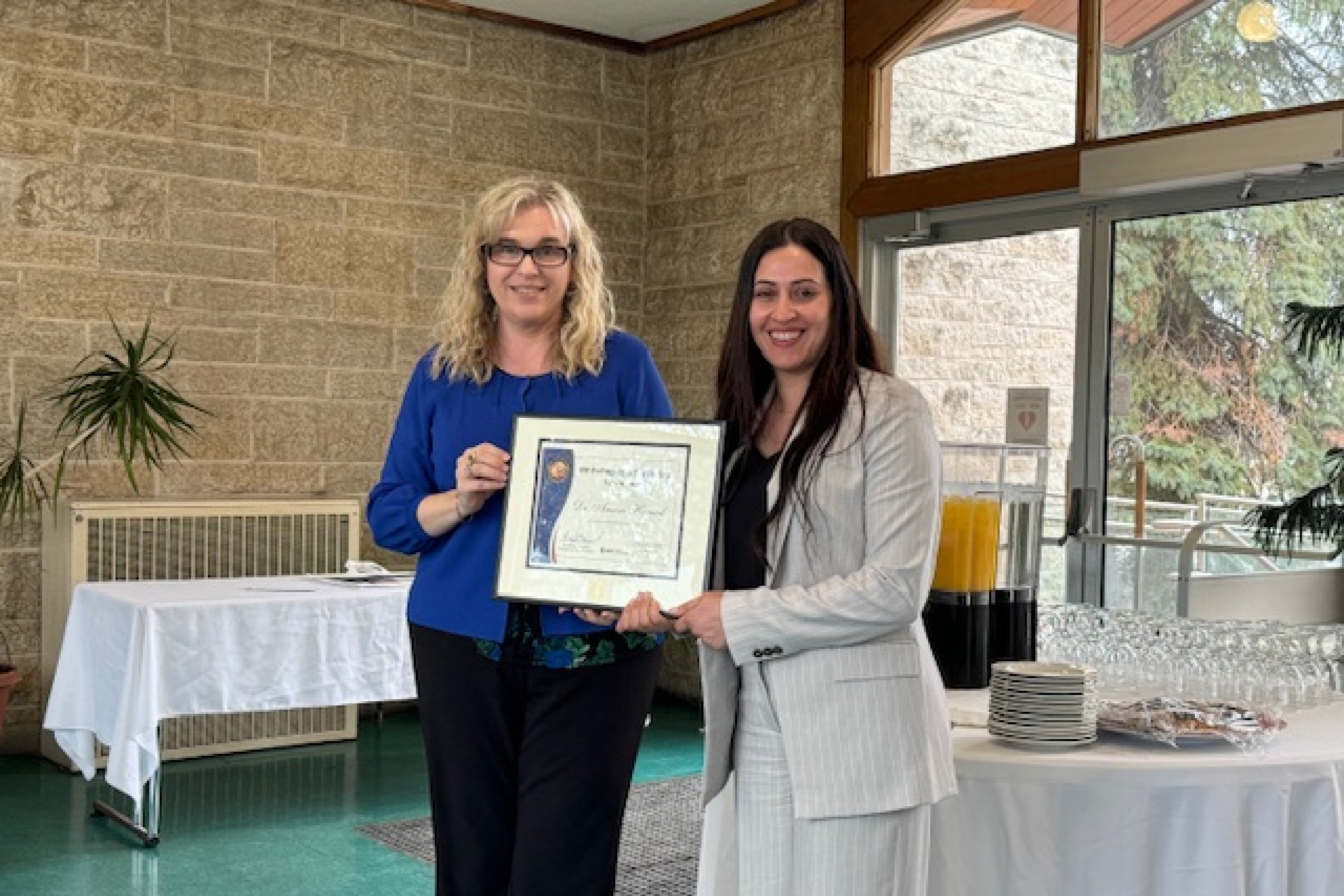 Dr. Kelley Main presents Dr. Amani Hamad with the Distinguished Postdoctoral Award.
