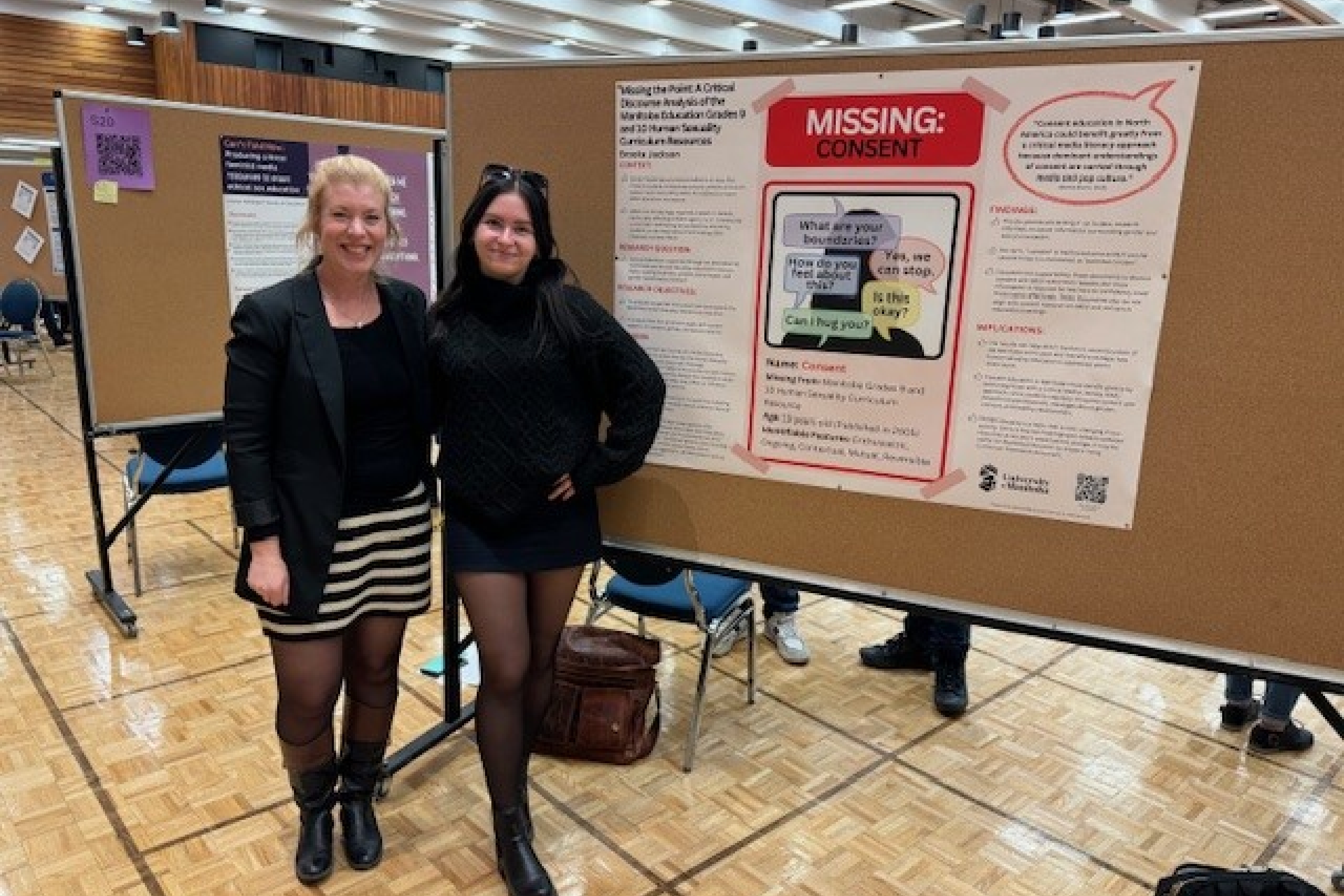two people stand in front of a research poster