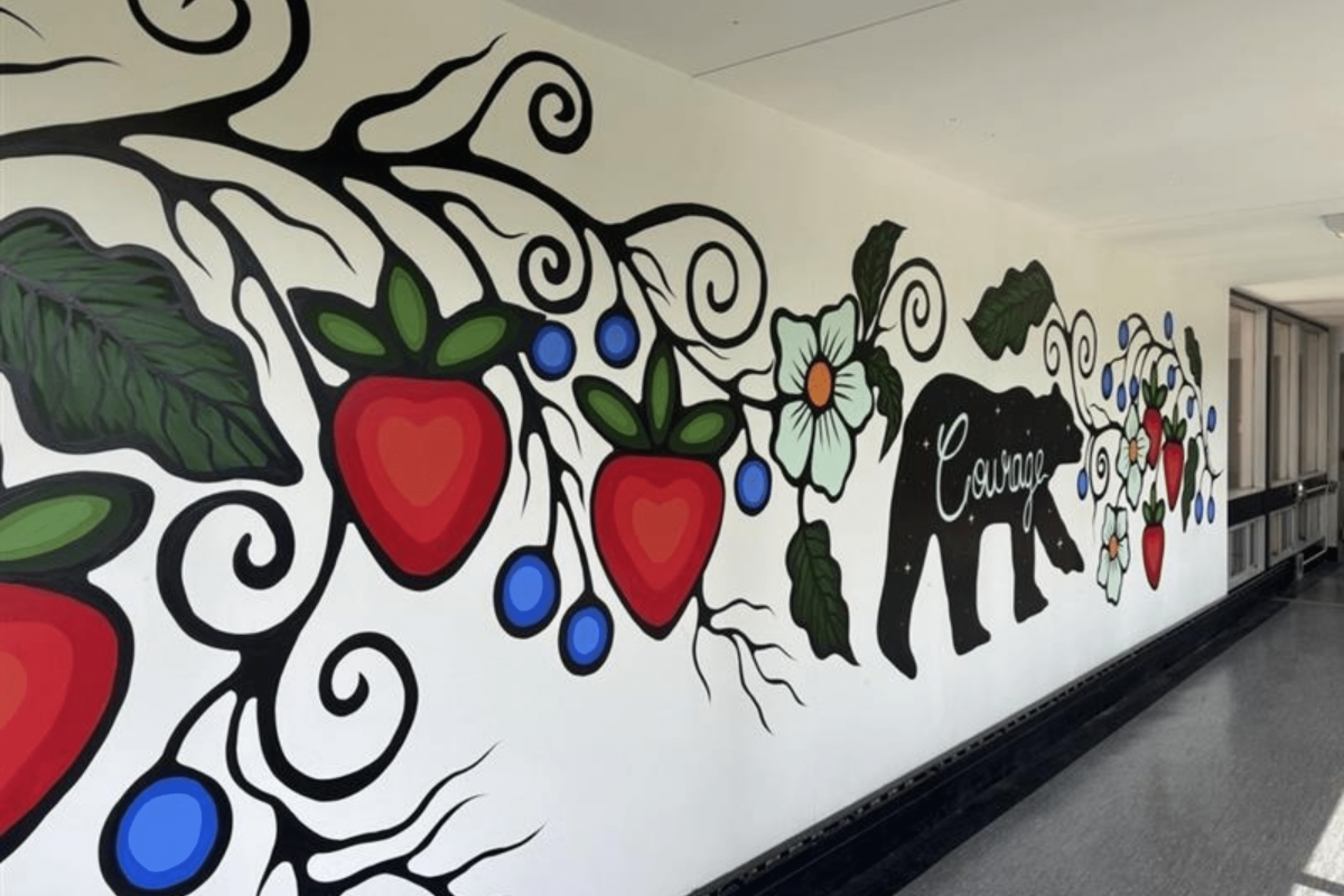 An indigenous mural depicting flowers, fruits and a bear along with the word "courage"