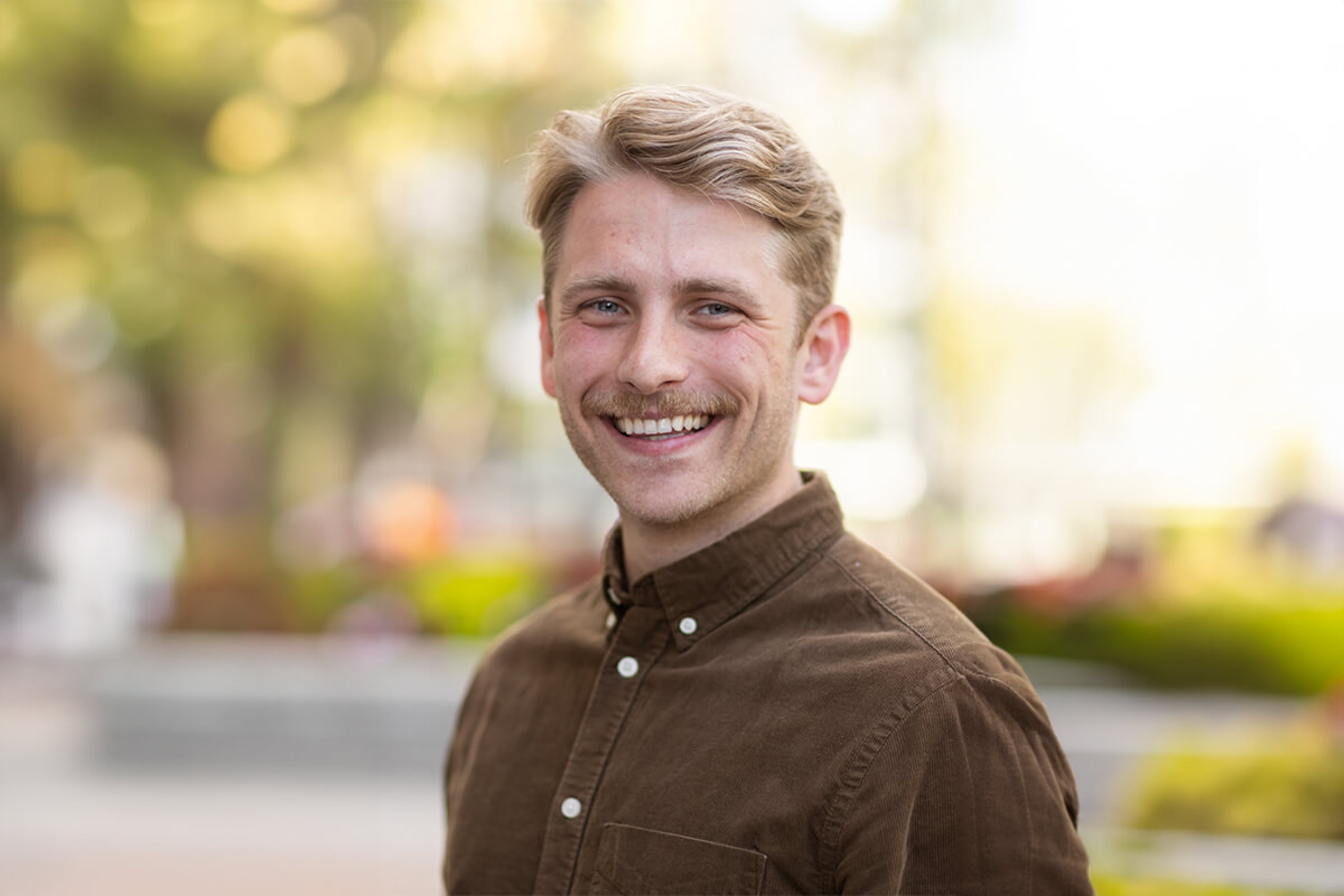 Dallas Murphy, a man with short blond hair and facial hair smiling for a photo.
