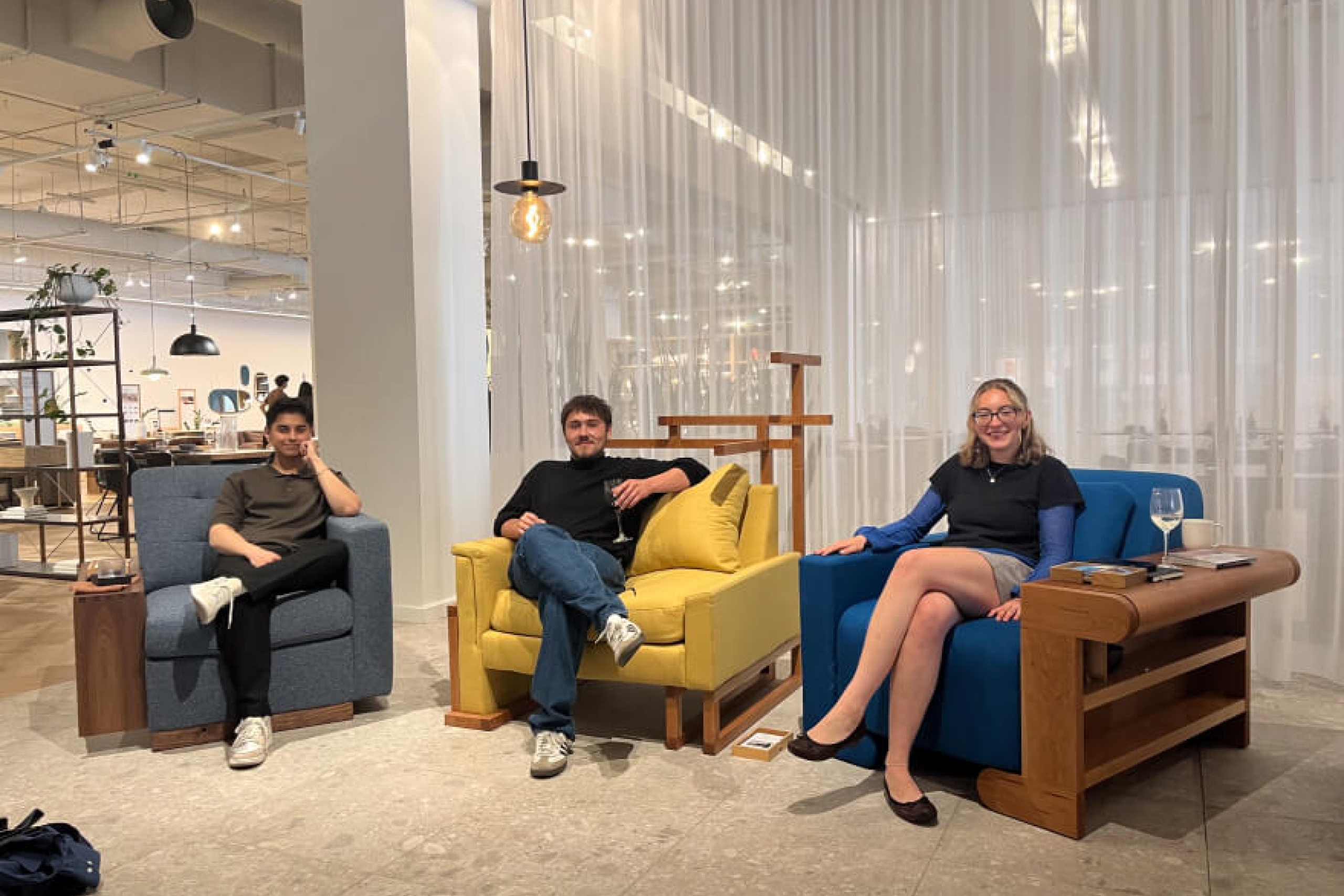 Students sit on their completed chairs on display at the EQ3 store.