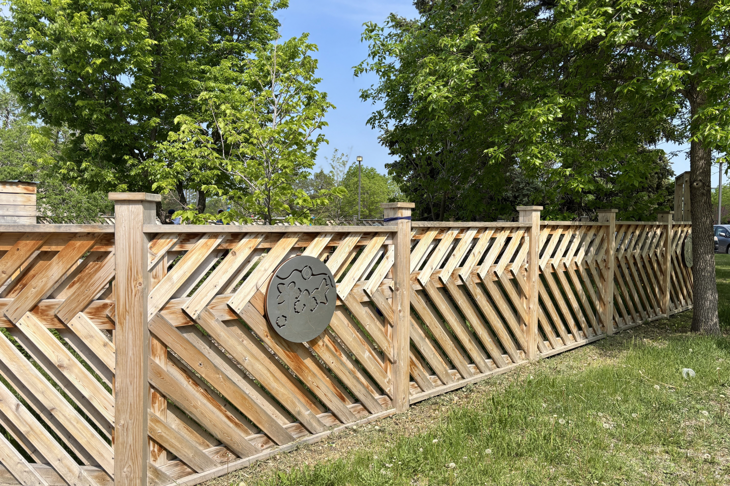 cedar fence with round, silver medallion