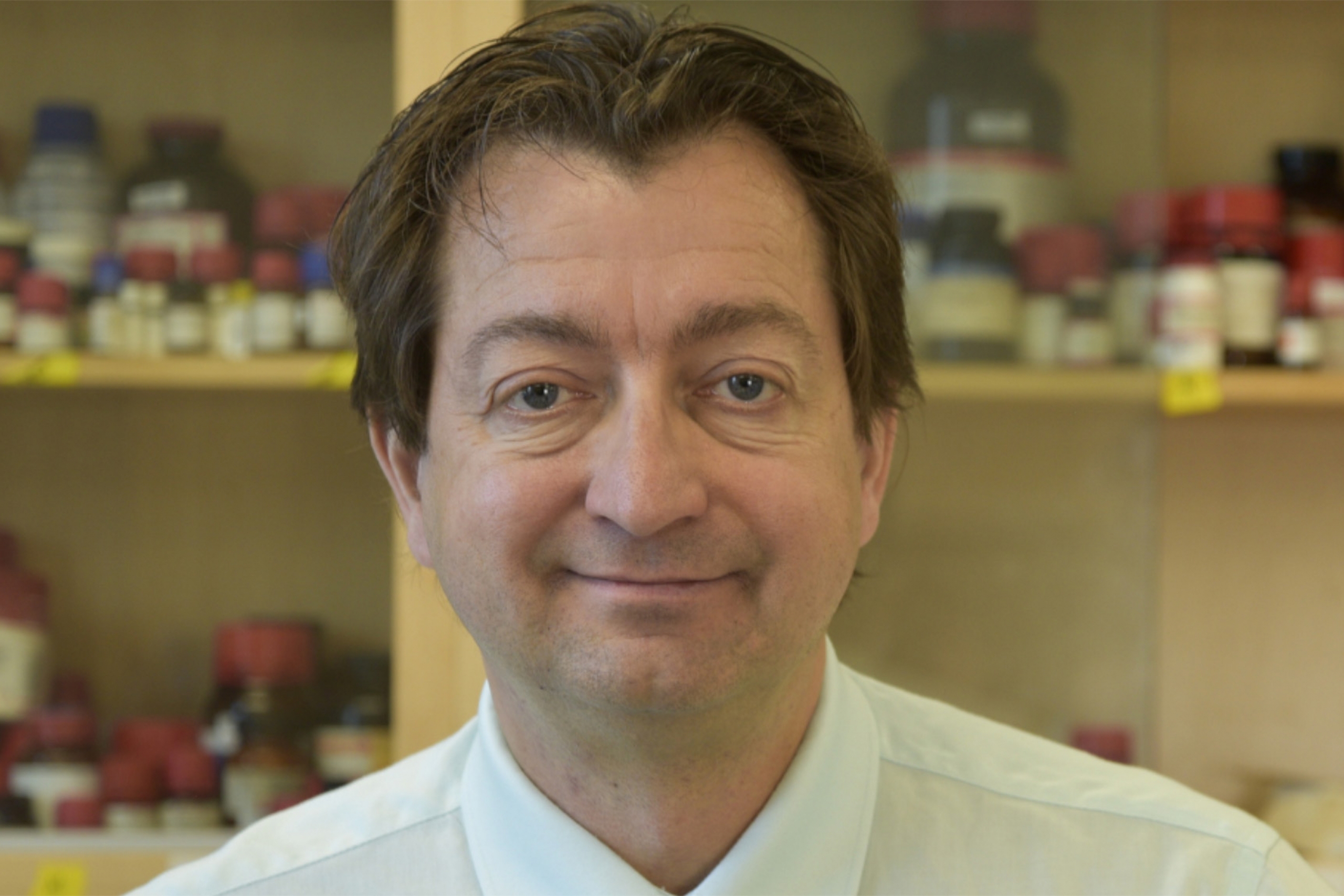 John Sorensen wearing a white collared shirt and smiling at the camera.