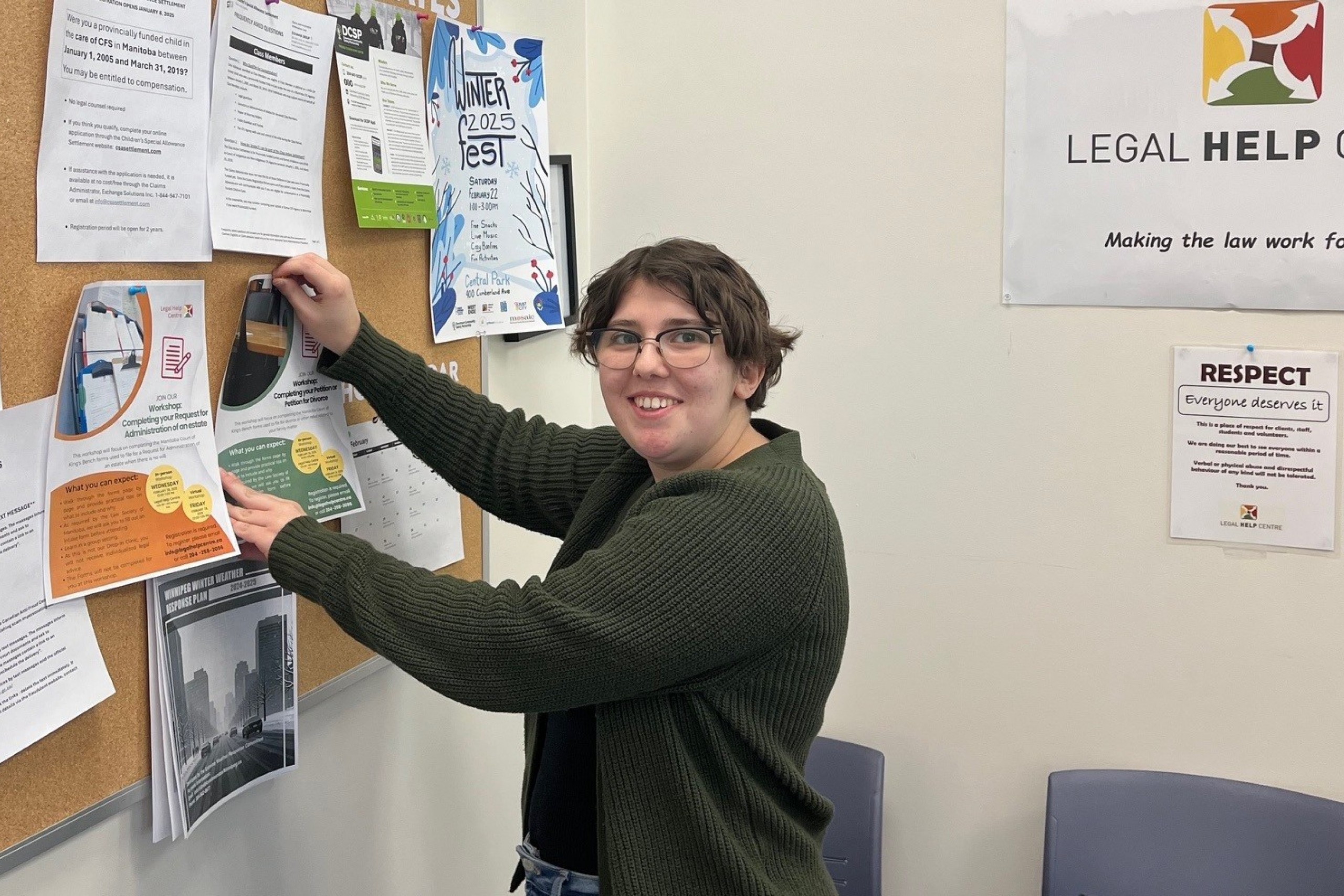 Monika Touzin posts on the bulletin board at the Legal Help Centre.