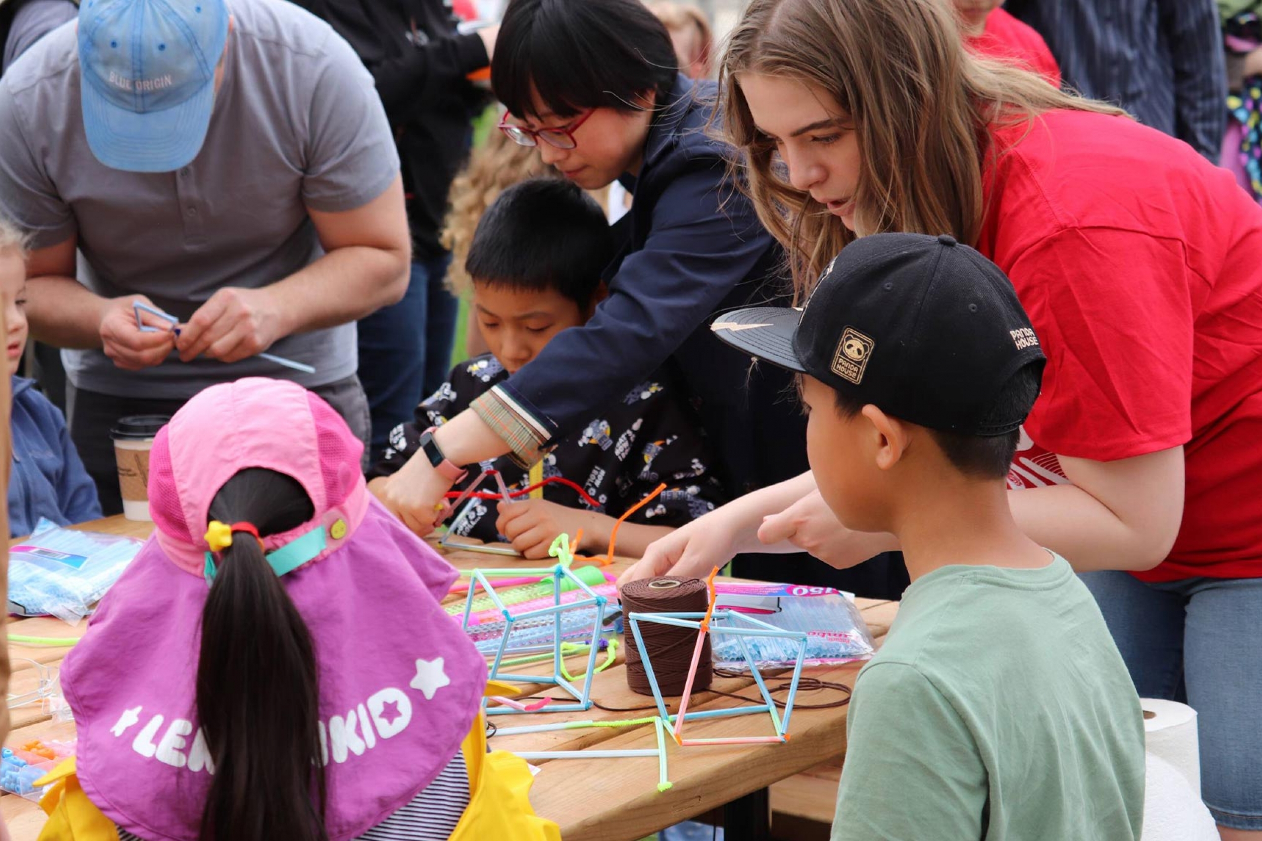 Science Rendezvous volunteer demonstrating an experiment to kids.
