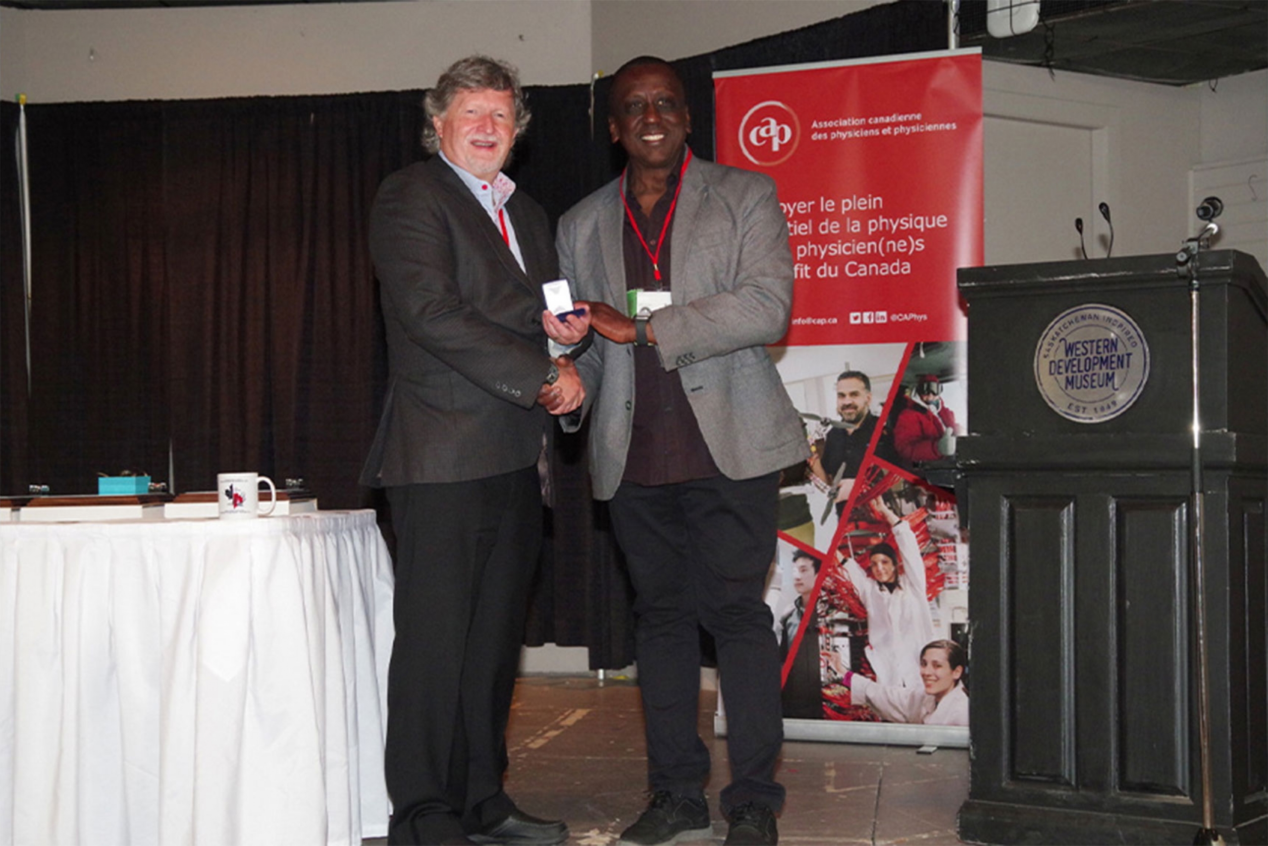 Stephen Pistorius on the stage receiving the 2025 CAP-COMP Peter Kirkby Memorial Medal.