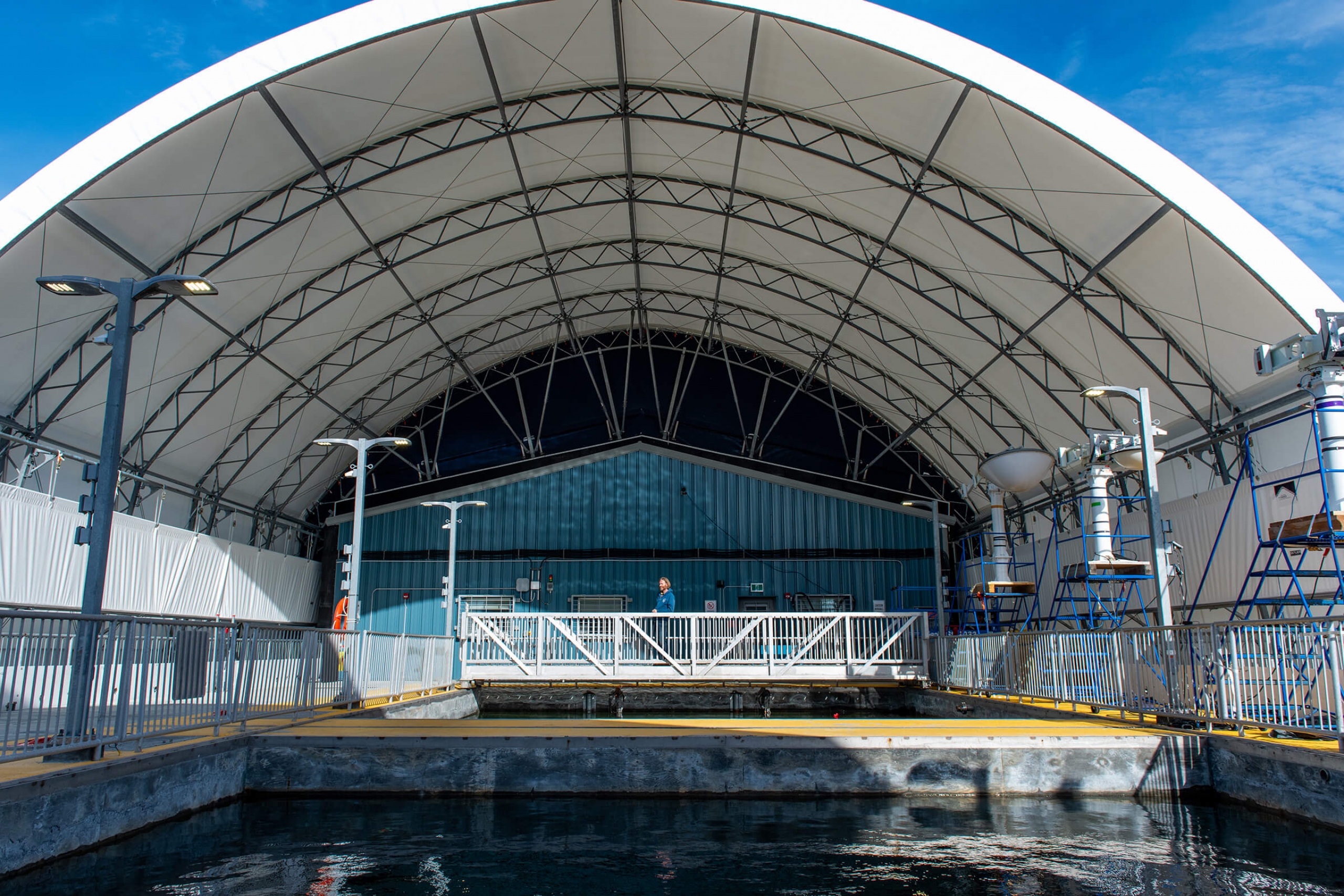 person standing inside a research facility overtop of the water