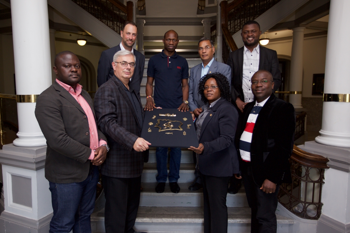 The delegation presented a gift to NCTR. The bronze plaque is an outline of Côte d'Ivoire with each piece representing a separate region of the country, with the Hands of Justice over all. (L-R) Arséne Assande, David T. Barnard, Ry Moran, Oleh Kam, Digvir S. Jayas, Marina Ahibie Bangrou, Yvon Mabofe and Paul Lamah. // Photo by Dan Gwozdz