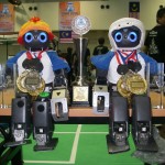 Small humanoid robots wearing gold medals
