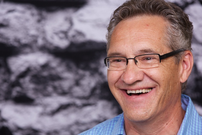 Andrew Halayko, a doctor with salt and pepper hair and black rimmed glasses, smiling