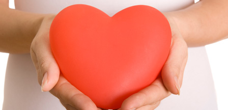 a red heart held in a person's hands