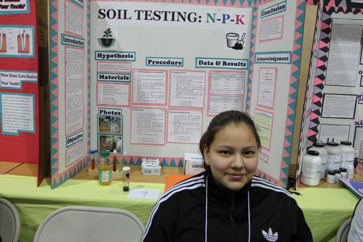 Manitoba First Nations Science Fair student sits in front of her project: Soil Testing