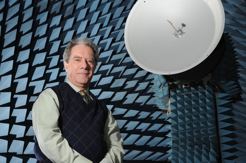 Lotfallah Shafai standing in front of a satelite.