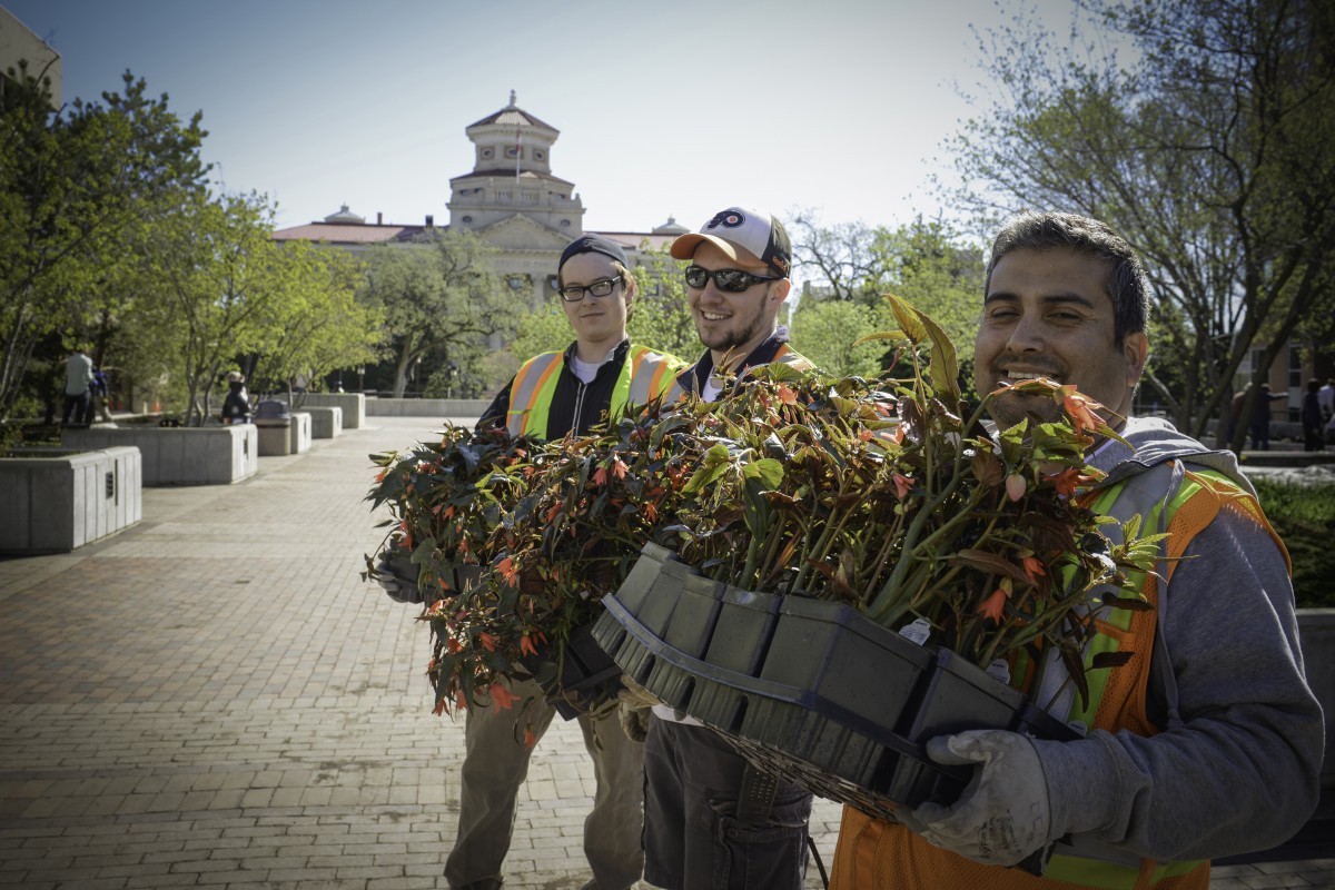 Campus Beautification day people smiling and holding flowers
