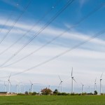 Wind Turbines and High Voltage Powerlines under a hopeful sky