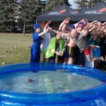 Radio host Ace Burpee jumps into icy water to raise money alongside U of M students for the United Way.