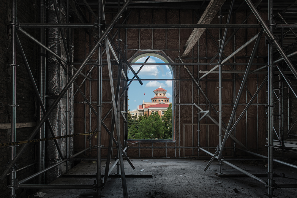 Viewing the administartion building through a window in tache hall surrounded by scaffolding