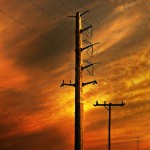 power lines against the orange sky of a setting sun