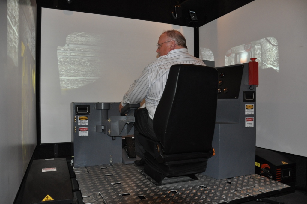 Dean, Dr. Norman Halden at the ThoroughTec Cybermine underground mining simulator operating a load-haul-dumper at the Northern Manitoba Mining Academy. Photo Credits: Rob Penner.