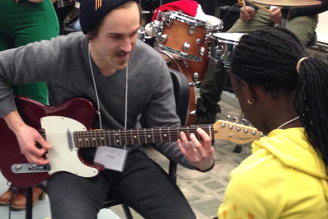 A U of M Jazz student (aka Jazz Buddy) mentors a participant in guitar technique during the CanU Jazz Academy.