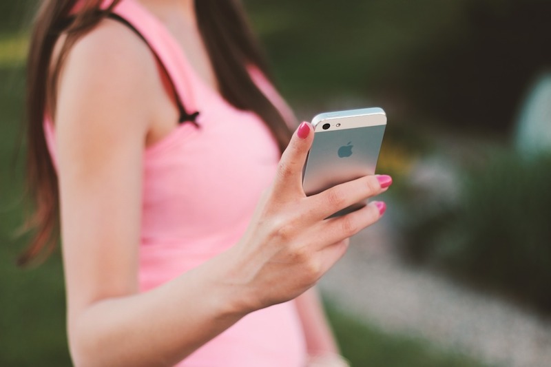 anonymous girl holds a cell phone