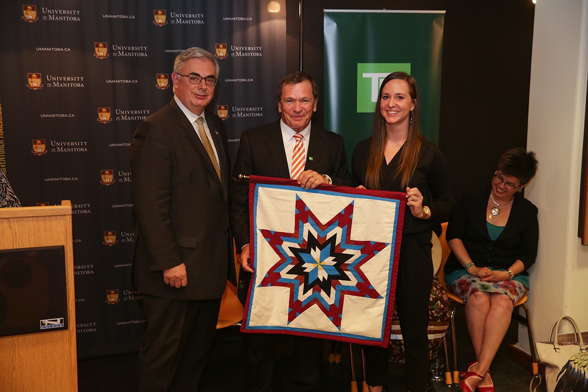 David Barnard, Frank McKenna and student Nicole Courrier with the unity blanket presented to TD Bank Group.