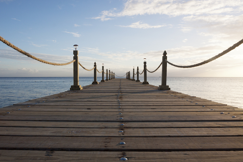 a dock extends into the lake's horizon