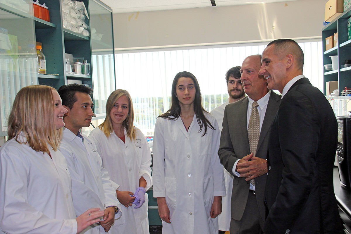 Students Daniell McAllister, Chris Cadonic, Taylor Morriseau, Ella Thomson, and Kevin Champagne-Jorgenson in the Albensi lab talk with Benedict Albensi and Minister Kevin Chief // Photo by Rebecca Krowelski