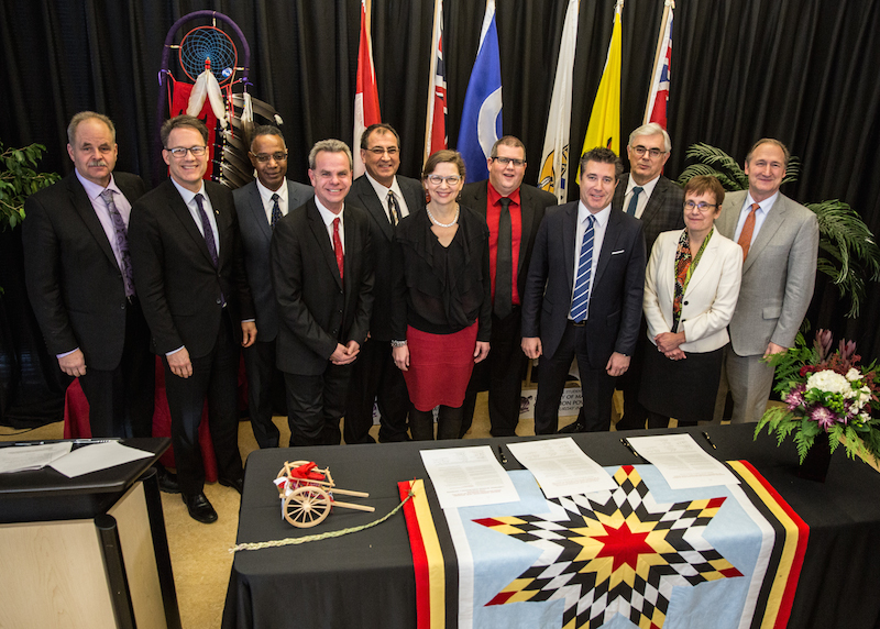 Presidents stand behind a table after signing the Indigenous Education Blueprint