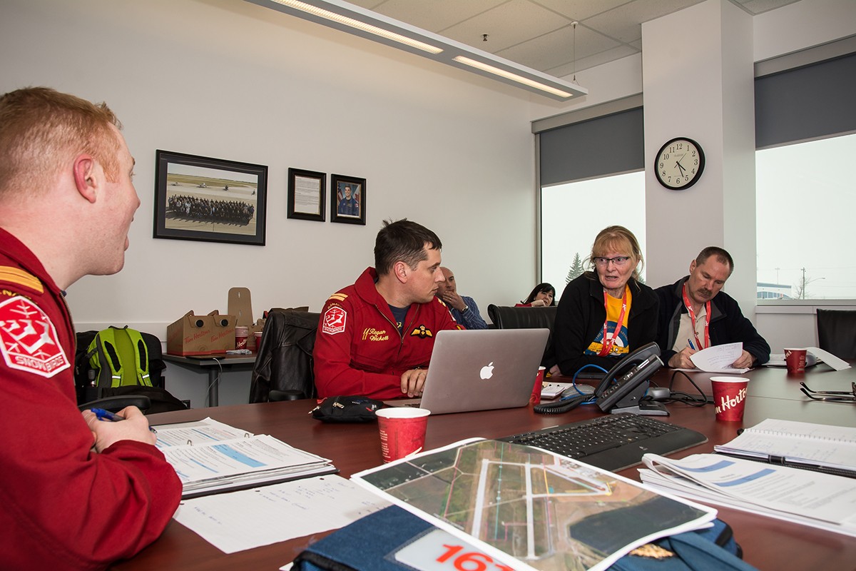 Jill Oakes (second from right) discusses plans for the airshow with her team and participants.