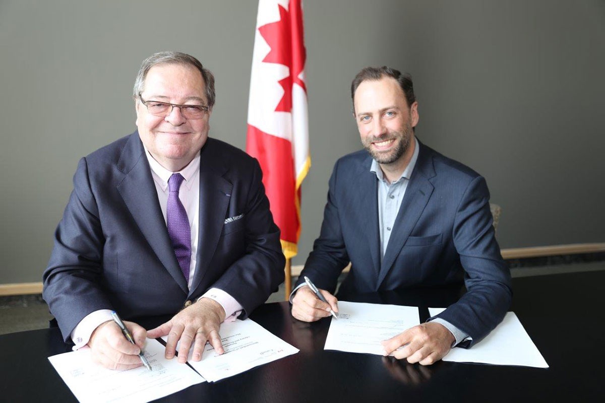 Guy Berthiaume (left) and Ry Moran formalizing their new agreement.