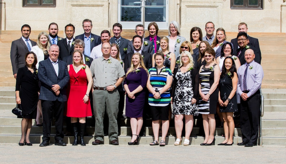 a graduating class standing in the sunshine