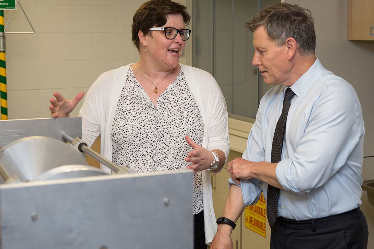 (L-R) Chemistry professor Jennifer van Wijngaarden and MP Terry Duguid look over a magnetic resonance chamber in a chemistry lab on Aug. 22, 2016.
