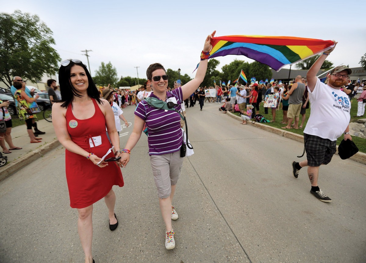 Michelle McHale (left) and her partner Karen Phillips lead thousands of revelers at Pride Steinbach on July 9, 2016. // PHOTO BY TREVOR HAGAN
