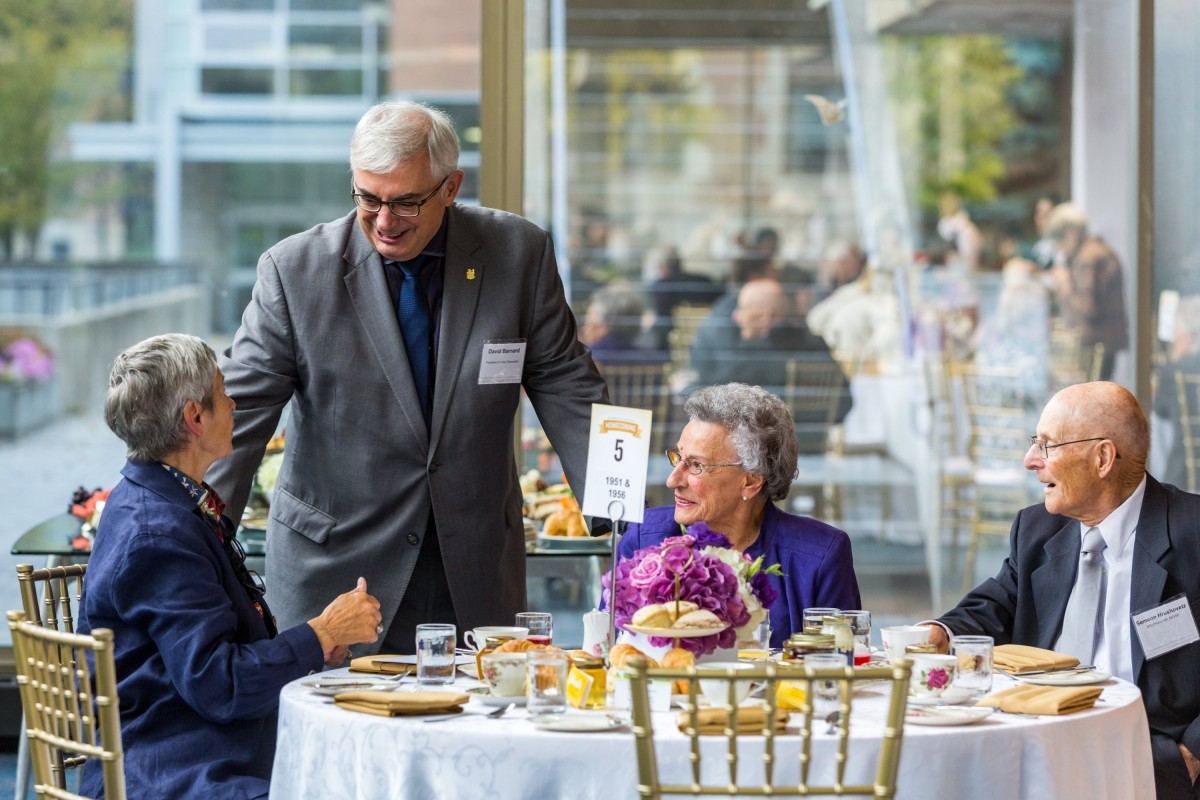 President Barnard speaking with alumni at the Chancellors Tea