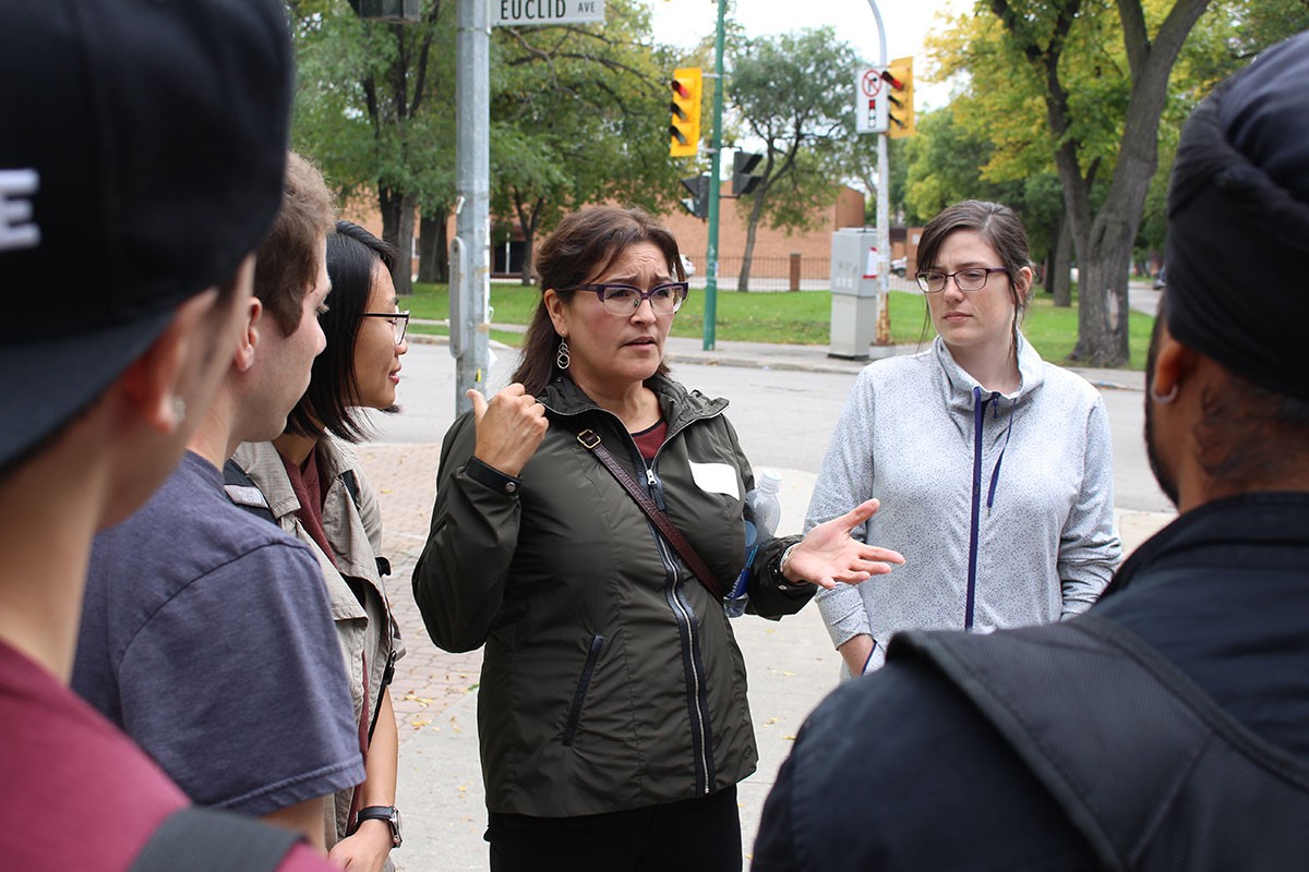 Karen Cook, Project Manager for Community Health Sciences, addresses first-year students during the Engaging in our Community bus tour.