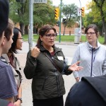Karen Cook, Project Manager for Community Health Sciences, addresses first-year students during the Engaging in our Community bus tour.