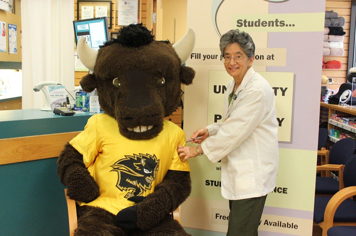 Billy the Bison knows that getting a flu shot from pharmacist Meera Thadani is the best way to ensure we all have 'herd immunity' on campus.