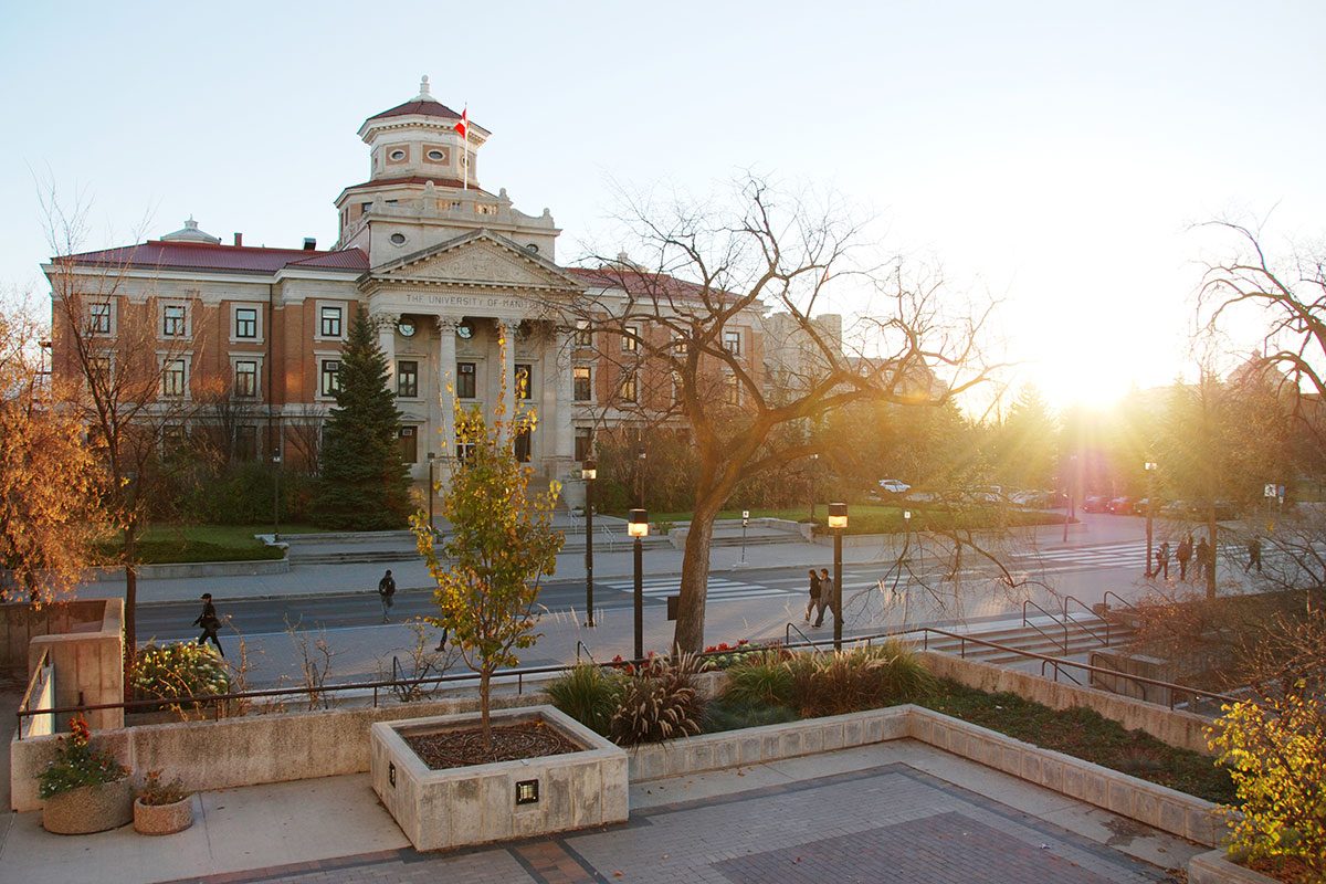 University of Manitoba administration buildin, with the sun rising behind it in autumn.