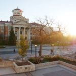 University of Manitoba administration buildin, with the sun rising behind it in autumn.