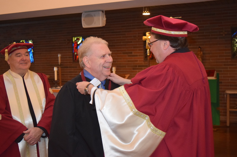 Ronald F. Smith [BSc/66, BEd /71, PostBacEd/91) receives honorary membership in the St. Paul’s College Assembly.